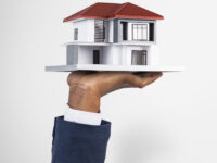 Hand holding house real estate and property model